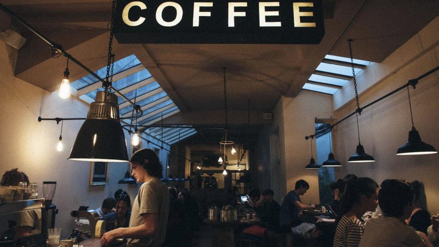Barista pulling an espresso shot at a cafe counter