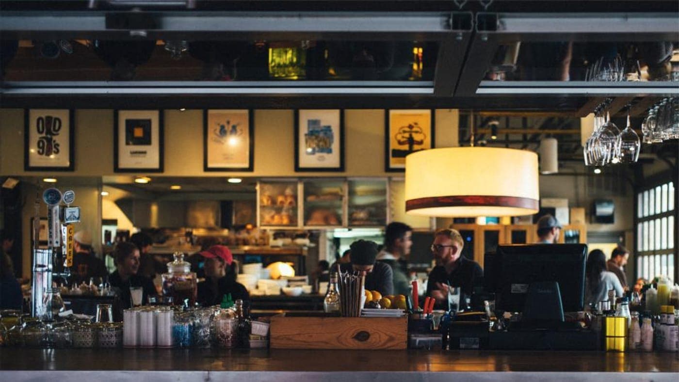 Bartender finishing a cocktail on a dark bar top